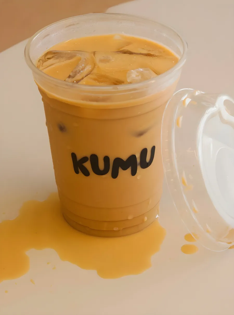 Latte helado de Kumu con su tapa a un lado