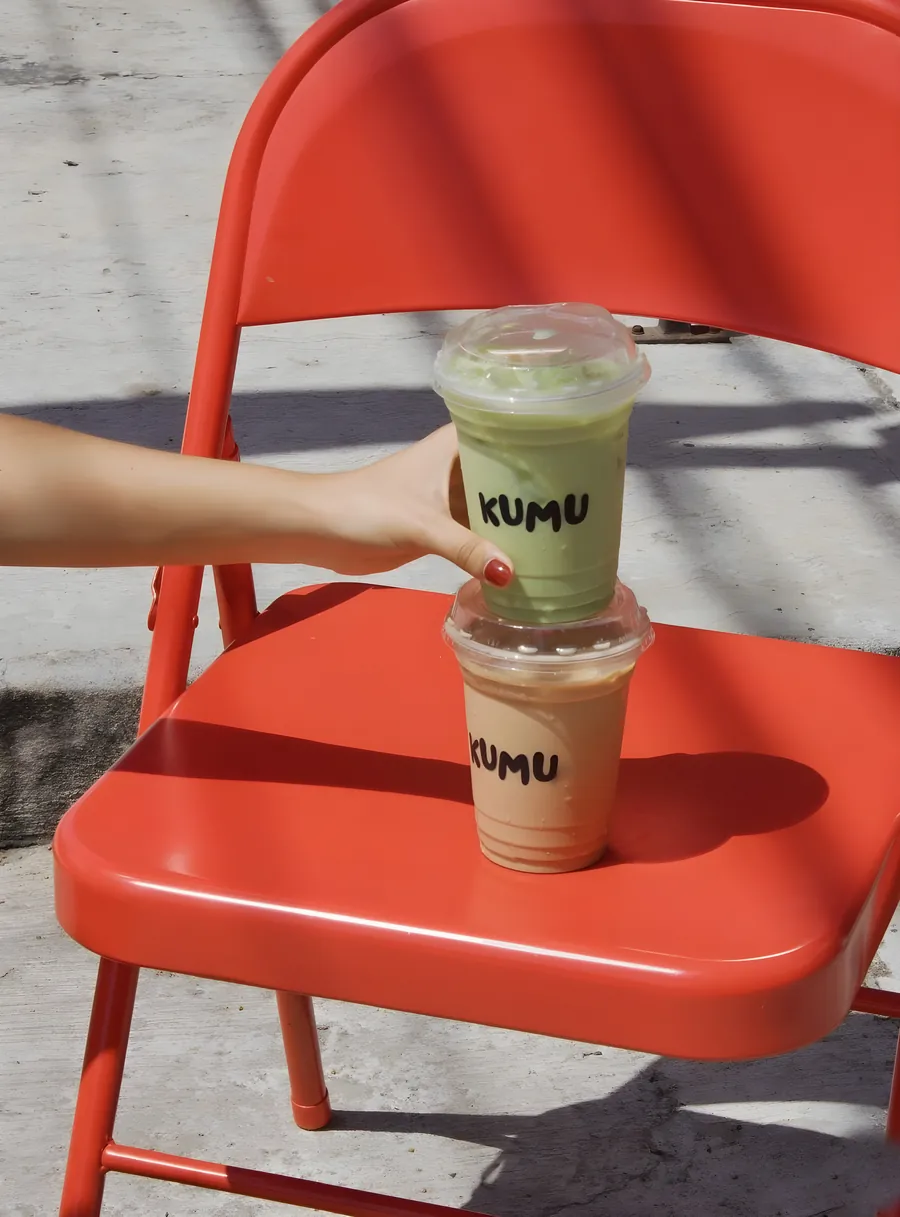 Dos bebidas de Kumu, de matcha y de chai, sobre una silla roja